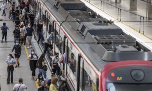 Viajeros suben a un tren de cercanías en la estación de tren de Santa Justa.