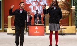 Dos niños de la residencia de San Ildefonso cantan un cuarto premio del Sorteo Extraordinario de la Lotería de Navidad, a 22 de diciembre de 2022, en Madrid.