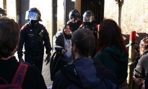 Una de les concentrades a les portes del domicili s'apropa als manifestants que hi ha davant el cordó policial