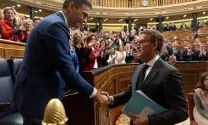 El presidente del Gobierno, Pedro Sánchez (i), saluda al presidente del PP, Alberto Núñez Feijóo (d), tras ser Sánchez votado de nuevo jefe del Ejecutivo en el debate de su investidura