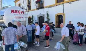 Vecinos de El Viso se acuden al camión cisterna que visita el pueblo para conseguir agua potable.