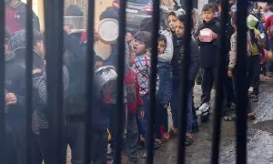 22/12/23 . Niños palestinos cargan ollas mientras hacen cola para recibir comida cocinada en una cocina benéfica en Rafah, en el sur de la Franja de Gaza.