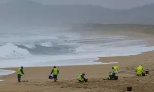 Operarios de empresas contratadas por la Xunta retiran los pellets o bolitas para fabricar plástico que aparecen en las playas gallegas y de Asturias, tras la caída de un contenedor de un barco el pasado diciembre, esta mañana en la playa de O Vilar, en e