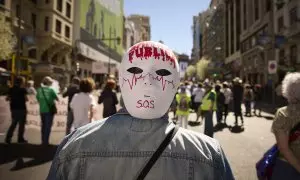 Varias personas marchan en la manifestación convocada por entidades sociales, profesionales de la sanidad y organizaciones sindicales por la defensa del sistema sanitario público madrileño, a 26 de marzo de 2023, en Madrid (España).