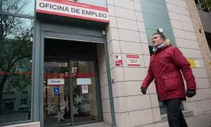 Una persona camina frente a la entrada de una oficina de empleo en Madrid, a 4 de diciembre de 2023