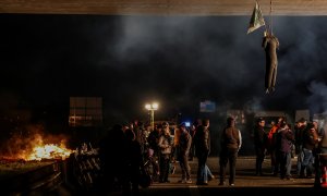 Los agricultores franceses cuelgan un muñeco de un puente y encienden una hoguera mientras cortan la A4, una autopista que conduce a París.