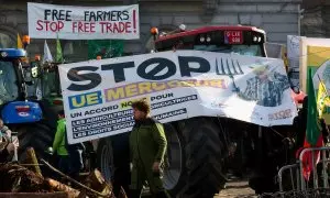 Un hombre camina junto a tractores y pancartas de la protesta de agricultores en Parlamento Europeo en Bruselas el 1 de febrero.