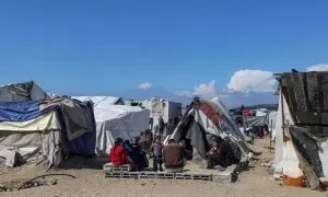 14-2-24 - Una familia palestina desplazada de Rafah sentada frente a su refugio en Deir Al Balah, en el sur de la Franja de Gaza, a 14 de febrero de 2024.