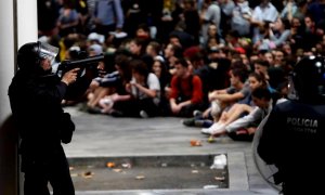 Policías antidisturbios ante los manifestantes concentrados en el aeropuerto del Prat de Barcelona tras la llamada de la plataforma Tsunami Democràtic.