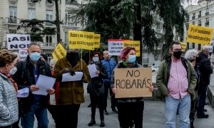 Varias personas con carteles, participan en una concentración a las puertas del Congreso de los Diputados para manifestar su disconformidad con el acuerdo alcanzado por Gobierno e Iglesia sobre las inmatriculaciones de los bienes de esta última, a 16 de f