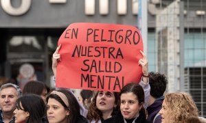 Una joven sujeta una pancarta durante una manifestación