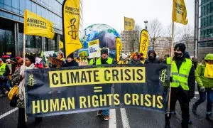 Miembros de Amnistía Internacional protestan en Bruselas por la crisis climática, a 3 de diciembre de 2023.