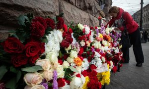 Mujer rusa lleva una flor para conmemorar a las víctimas mortales del atentado terrorista en el auditorio Crocus City Hall, en Moscú, a 24 de marzo de 2024.