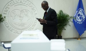 Un hombre lee su teléfono móvil en la sede del FMI en las jornadas previas a la Reunión de Primavera del organismo internacional y del Banco Mundial, en su sede en Washington. AFP/Getty/Alex Wong