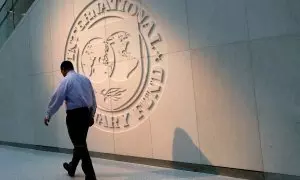 Un hombre pasa caminando por delante del logo del Fondo Monetario Internacional (FMI), en su sede en Washington.