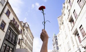 Una mujer sostiene un clavel rojo durante una manifestación para conmemorar el aniversario de la Revolución de los Claveles, a 25 de abril de 2021, en Oporto.