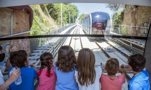 Diversos nens observen la Cuca de Llum, el funicular del Tibidabo