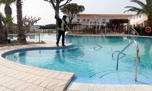 Un treballador netejant la piscina del càmping Les Medes de l'Estartit