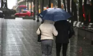 Dues persones passegen amb paraigua per la Rambla Nova de Tarragona, aquest divendres