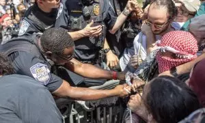 Un oficial de policía les quita la cuerda de una bandera palestina a unos estudiantes que participaban en las protestas estudiantiles pro Palestina en la Universidad George Washington.