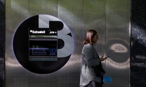 Una mujer pasa por delante de un cajero automático del Banco Sabadell en la Gran Via de Bilbao. REUTERS/Vincent West