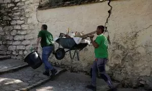 Un par de trabajadores cargan con una carretilla en una calle empinada de la localidad malagueña de Ronda. REUTERS/Jon Nazca