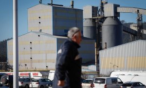 Foto de archivo de un hombre caminando frente a la fábrica de Alcoa, a 24 de enero de 2024, en San Cibrao, Lugo.