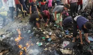 Adultos y niños buscando entre los escombros en un campamento de Rafah, después de los ataques de Israel, a 27 de mayo de 2024.