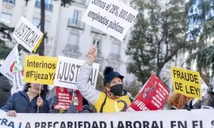 Un grupo de personas con carteles durante una manifestación de interinos frente al Congreso de los Diputados.