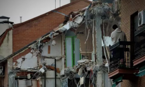 Imagen de archivo de un vecino mirando las obras de demolición de una vivienda en San Fernando de Henares.