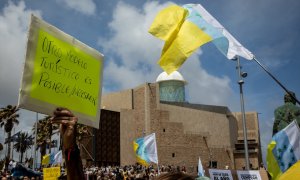 Una persona sujeta un cartel de protesta durante una manifestación contra el modelo turístico, a 20 de abril de 2024, en Las Palmas de Gran Canaria, Gran Canaria, Canarias (España).