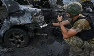 Un experto analiza un coche destruido por las tropas rusas en Vilniansk, a 29 de junio de 2024.