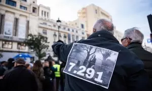 Un hombre lleva un cartel con el número de residentes muertos en la pandemia durante una manifestación en memoria de los residentes fallecidos durante la primera ola de la pandemia,