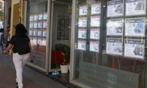 Una mujer pasa por delante de la oficina de una inmobiliaria en Madrid. EFE/J.J.Guillen