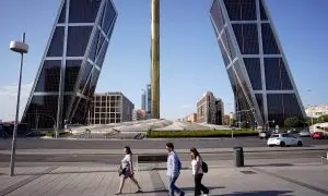 Varias personas pasan por la madrileña Plaza de Castilla, en plena cuarta ola de calor. REUTERS/Ana Beltran