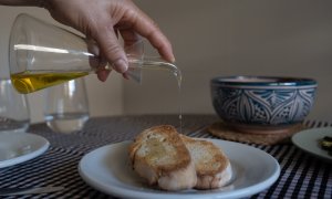 Una persona echa aceite de una aceitera a una tostada en Barcelona, Catalunya (España).