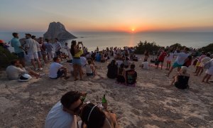 Foto de archivo de varios grupos de personas  en la Cala d'Hort, en Ibiza, Illes Balears.