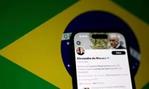 La cuenta en la red social X del juez de la Corte Suprema de Brasil Alexandre de Moraes, encargado de la investigación de la red social propiedad de Elon Musk, en un smartphone con la bandera brasileña de fondo. REUTERS/Jorge Silva