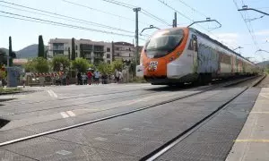 10/09/2024 - Un tren de Rodalies circula per Montcada i Reixac al costat d'un pas a nivell.