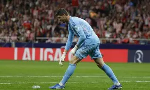 El portero del Real Madrid Thibaut Courtois retira un objeto lanzado desde la grada, durante el partido de la LaLiga EA Sports que Atlético de Madrid y Real Madrid disputron este domingo