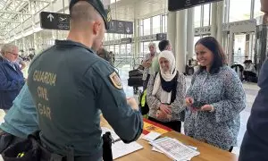 Agentes de la Guardia Civil española comprueban los documentos de los ciudadanos españoles nacionalizados antes de ser evacuados del Líbano, en el aeropuerto internacional Beirut-Rafik Hariri.