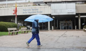 Un hombre con paraguas pasa frente a las oficinas de la Tesorería General de la Seguridad Social en Madrid. E.P./Marta Fernández / Europa Press