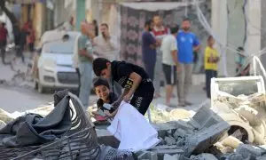 Unos niños palestinos revisan entre los escombros tras un bombardeo israelí en el campamento de Bureij, en el centro de Gaza.