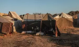 Una familia palestina desplazada se sienta en su tienda de campaña en el campo de refugiados de Al Nuseirat, en el sur de la Franja de Gaza, el 12 de octubre de 2024.