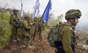 Soldados de las Fuerzas de Defensa de Israel conversan junto banderas israelíes en territorio del sur de Líbano, zona controlada por el ejército israelí