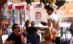 09/08/2024 - Un cambrer en una terrassa d'un bar de Gràcia, a Barcelona.