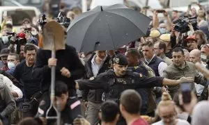 El rey Felipe (c), durante su visita a Paiporta este domingo. Gritos de 'fuera', así como lanzamiento de barro, están recibiendo a la comitiva de los reyes de España, el presidente del Gobierno, Pedro Sánchez, y el president de la Generalitat, Carlos Mazó