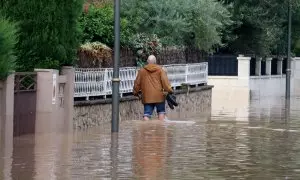 Un home caminant per un carrer inundat de la urbanització La Móra de Tarragona