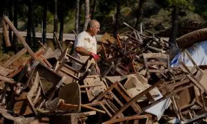 Un hombre entre mobiliario afectado tras el paso de la DANA.