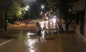 Un nen just abans del pont que dona accés al nucli dels Valentins i per sobre del qual ha saltat l'aigua del barranc